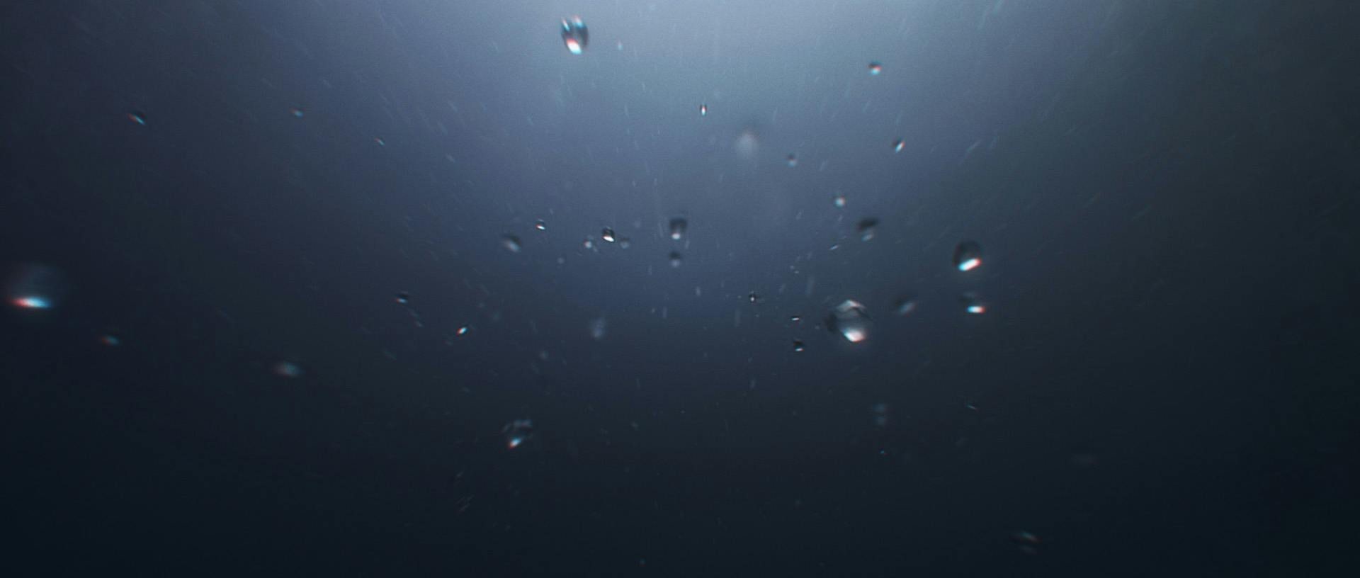 Bubblor under vattnet i ett mörkt hav.